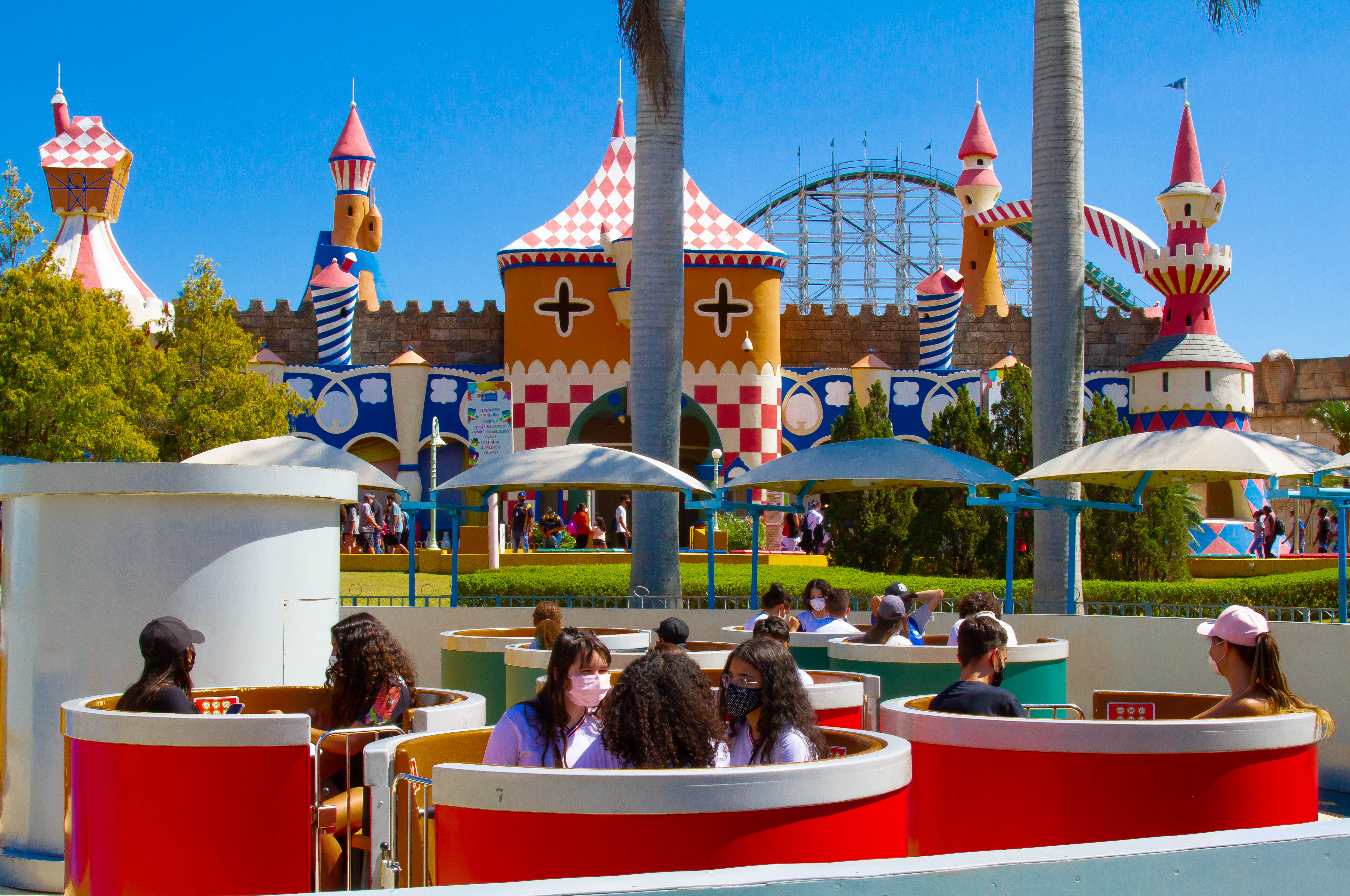 A imagem mostra crianças dentro de cadeiras que giram automaticamente no parque de diversões.