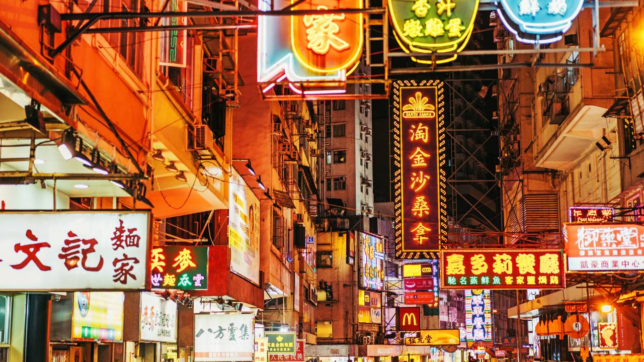 Rua comercial Kowloon, Hong Kong, na Ásia, com lojas e placas em neon