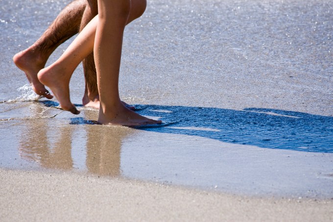 Casal caminha pela praia