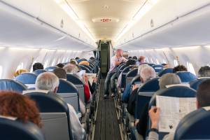 Cabine de um voo comercial de avião da Air France com passageiros a bordo lendo jornal
