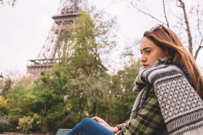 Mulher francesa triste em frente a Torre Eiffel em Paris