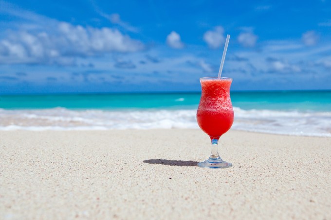 Drink de batida de frutas na areia da praia na beira do mar