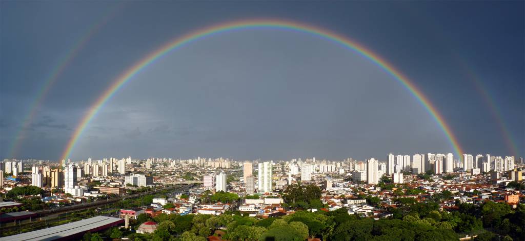 Vista da cidade de São Paulo com arco iris duplo em dia de chuva
