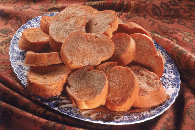 A receita feita com pães, leite e ovos foi criada para recuperar mulheres após o parto. Natural da península ibérica, o doce foi caindo no gosto do povo aos poucos, sendo que no começo do século 20 se tornou um alimento comum nas tabernas de Madri, na Espanha. Acompanhado de vinho, a <a href="https://mdemulher.abril.com.br/gastronomia/7-receitas-de-rabanada-para-voce-arrasar-no-doce-mais-tradicional-do-natal/" target="_blank" rel="noopener">rabanada</a> também é muito associada aos períodos religiosos, como a quaresma, talvez pela falta de carne no cardápio. Seus primeiros registros históricos são datados do século 14, em Portugal, e foram feitos pelo poeta espanhol Juan del Encina. Já a primeira receita documentada pertence ao livro de Francisco Martinez Montiño, servidor da Coroa Real da Espanha no período. <strong><a href="https://mdemulher.abril.com.br/gastronomia/7-receitas-de-rabanada-para-voce-arrasar-no-doce-mais-tradicional-do-natal/" target="_blank" rel="noopener">Veja aqui receitas de rabanada</a></strong> A receita feita com pães, leite e ovos foi criada para recuperar mulheres após o parto. Natural da península ibérica, o doce foi caindo no gosto do povo aos poucos, sendo que no começo do século 20 se tornou um alimento comum nas tabernas de Madri, na Espanha. Acompanhado de vinho, a <a href="https://mdemulher.abril.com.br/gastronomia/7-receitas-de-rabanada-para-voce-arrasar-no-doce-mais-tradicional-do-natal/" target="_blank" rel="noopener">rabanada</a> também é muito associada aos períodos religiosos, como a quaresma, talvez pela falta de carne no cardápio. Seus primeiros registros históricos são datados do século 14, em Portugal, e foram feitos pelo poeta espanhol Juan del Encina. Já a primeira receita documentada pertence ao livro de Francisco Martinez Montiño, servidor da Coroa Real da Espanha no período. <strong><a href="https://mdemulher.abril.com.br/gastronomia/7-receitas-de-rabanada-para-voce-arrasar-no-doce-mais-tradicional-do-natal/" target="_blank" rel="noopener">Veja aqui receitas de rabanada</a></strong>