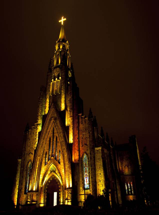 À noite, um jogo de luzes coloridas ilumina a fachada da Igreja Matriz de N. S. de Lourdes, em Canela (RS)