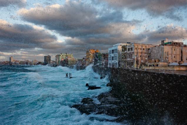 O muro centenário do Malecón, a famosa orla marítima de Havana, protege a cidade dos golpesdo mar revolto. Em dias mais calmos, moradores e turistas saem a passeio na calçada.