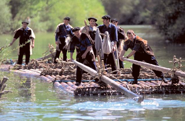 Homens praticam o Almadia (rafting com jangada) em rio na província de Navarra Homens praticam o Almadia (rafting com jangada) em rio na província de Navarra