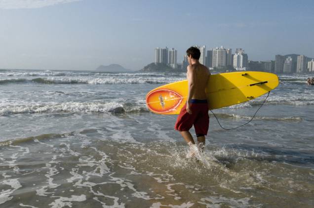 Surfista na Praia de Pitangueiras, a orla central do Guarujá é repleta de restaurantes, bares e lojas