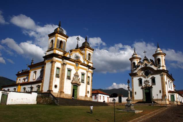 As igrejas de São Francisco de Assis (à esquerda) e de Nossa Senhora do Carmo, e o Pelourinho no centro da Praça Minas Gerais em Mariana (MG)