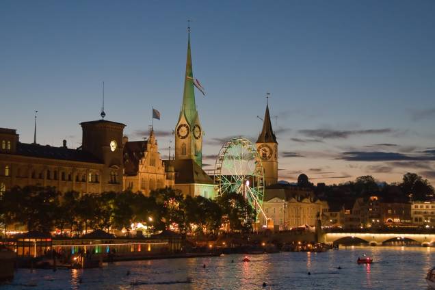 Vista noturna das igrejas Fraumünster e St. Peterskirche, a partir do rio Limmat, em Zurique