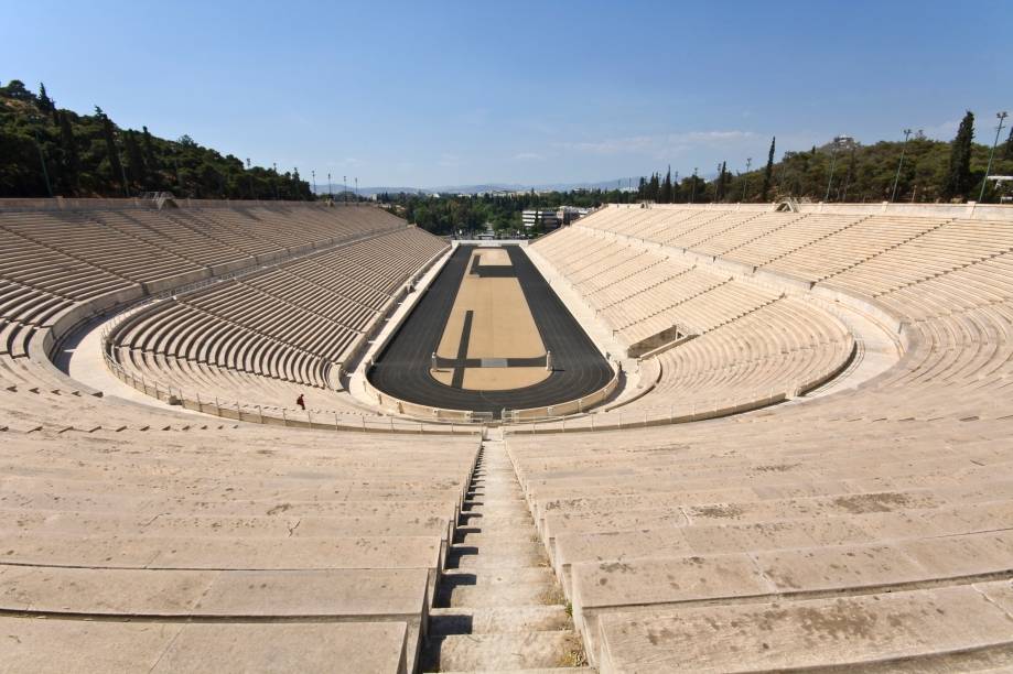 <strong>Atenas, Grécia (1896/ 2004)</strong><br />    Como diria o Barão de Coubertin, “o importante não é vencer, mas sim competir. E com dignidade”. A frase imortalizada na história do esporte também marca o início das Olimpíadas. Após contar com um incentivo de um milionário local, <a href="https://viajeaqui.abril.com.br/cidades/grecia-atenas" rel="Atenas " target="_blank">Atenas </a>sediou a primeira edição dos jogos esportivos da era moderna, que ocorreram em 1896. Depois de dar início ao maior evento esportivo da história, a capital grega esperou mais de cem anos para receber novamente os Jogos Olímpicos, que retornaram à cidade em 2004.        Palco de duas edições do evento, o <a href="https://viajeaqui.abril.com.br/estabelecimentos/grecia-atenas-atracao-estadio-panathinaiko" rel="estádio Panathinaiko " target="_blank"><strong>estádio Panathinaiko</strong> </a>é um dos símbolos do ideal grego e hoje recebe os atletas que conquistaram feitos importantes para o país. Outras atrações importantes são o <a href="https://viajeaqui.abril.com.br/estabelecimentos/grecia-atenas-atracao-acropole" rel="Parthenon " target="_blank">Parthenon </a>e o <a href="https://viajeaqui.abril.com.br/estabelecimentos/grecia-atenas-atracao-museu-da-acropole" rel="Museu da Acrópole" target="_blank">Museu da Acrópole</a>