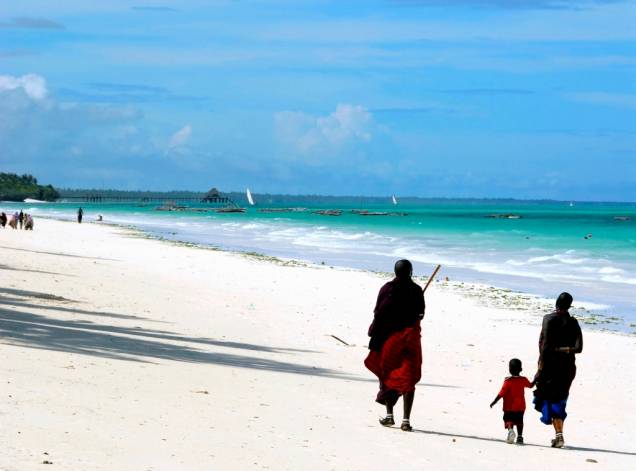 Família masai passeando na praia Kiwengwa, em Zanzibar, um arquipélago tanzaniano no oceano Índico
