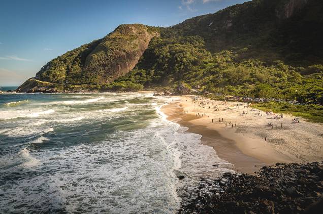 A chegada às duas mais belas praias do litoral carioca (Prainha e <a href="http://viajeaqui.abril.com.br/estabelecimentos/br-rj-rio-de-janeiro-atracao-praia-de-grumari" target="_blank">Grumari</a>, mais à frente) já impressiona: serpenteando pela estrada, numa das curvas, avista-se o mar verde da Prainha, cercado por morros e areia fofa. Com estrutura organizada de estacionamento, ducha e quiosque, é só curtir o visual e beliscar alguma porção por ali mesmo.