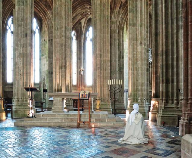 Peregrino reza em um dos altares do interior da Abadia do Mont Saint-Michel