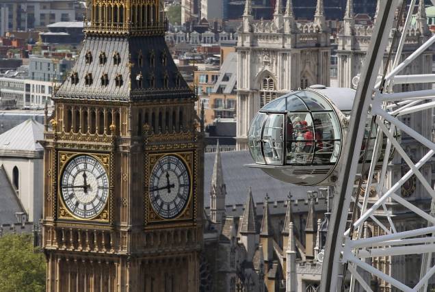 Vista da Torre do Relógio do Parlamento Britânico, tendo a London Eye em primeiro plano; as 32 cabines podem comportar 15 mil visitantes por dia e a volta completa dura meia hora
