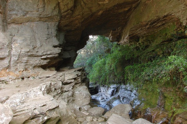 No extremo sul do <a href="https://viajeaqui.abril.com.br/estabelecimentos/br-mg-conceicao-do-ibitipoca-atracao-parque-estadual-do-ibitipoca" rel="Parque Estadual do Ibitipoca" target="_blank">Parque Estadual do Ibitipoca</a>, está a gruta Ponte de Pedra, uma espécie de viaduto rochoso sob o qual a umidade criou um espetacular forro de líquens, musgos e samambaias