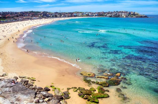 <strong><a href="http://viajeaqui.abril.com.br/cidades/australia-sydney" rel="Sydney (Austrália)" target="_blank">Sydney (Austrália)</a></strong>                                                Sydney é a cidade mais populosa da Austrália, com uma paisagem predominantemente urbana e cosmopolita. Mas, na metrópole, o turista também pode relaxar sobre faixas de areia agradáveis e, durante o verão do Hemisfério Sul, extremamente calorentas. A praia mais famosa da região da cidade é, sem dúvida, Bondi Beach, localizada a apenas 15 quilômetros do centro de Sydney e sempre animada por turistas e australianos. No local é possível encontrar ótimos restaurantes, bares e até lojinhas de açaí (a comunidade brasileira na região é enorme).