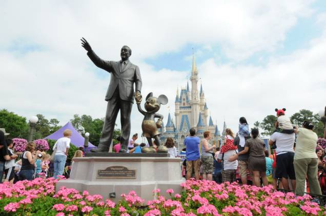 Estátua de Walt Disney com o Mickey Mouse e o Castelo da Cinderela, ao fundo, no parque temático Magic Kingdom. Estima-se que 17 milhões de turistas visitem o parque todo ano