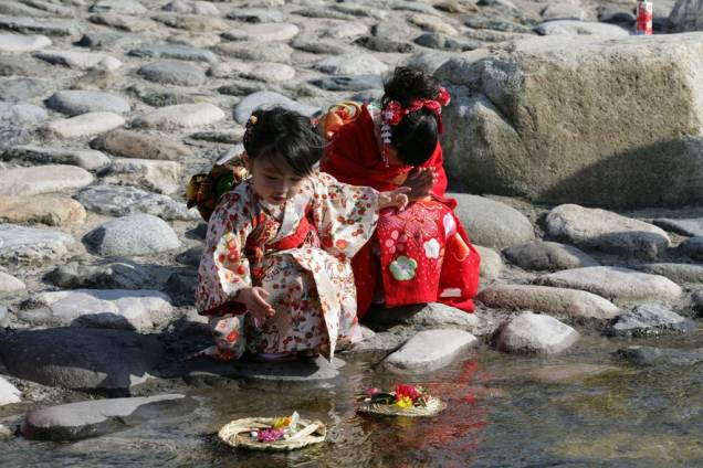 Meninas enviam para o mar um barquinho de palha com treze bonequinhos de papel, num ritual chamado nagashibina, realizado no dia das meninas. Tottori, centro-leste do Japão