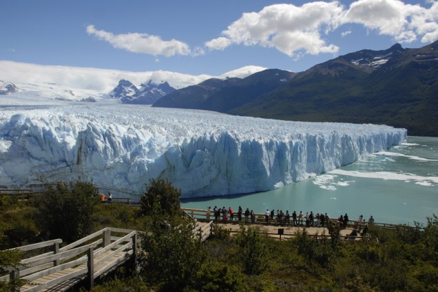 Na passarela de madeira, os visitantes veem os blocos que se desprendem da Geleira Perito Moreno e caem no lago, produzindo sons ensurdecedores