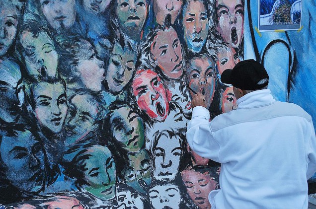 Artista retocando sua obra no muro