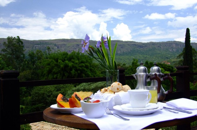 O café da manhã é servido em um deck com vista para a Serra de São José, no ponto mais alto do terreno da pousada