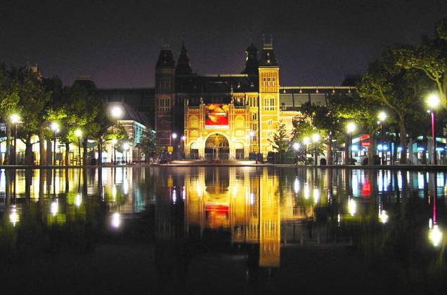 O <a href="http://viajeaqui.abril.com.br/estabelecimentos/holanda-amsterda-atracao-rijksmuseum" rel="Rijksmuseum" target="_blank">Rijksmuseum</a> à noite, em Amsterdã - um dos pontos mais icônicos da cidade