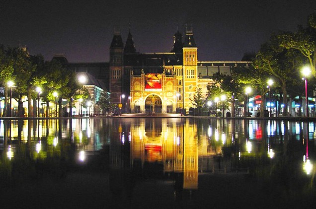 O <a href="https://viajeaqui.abril.com.br/estabelecimentos/holanda-amsterda-atracao-rijksmuseum" rel="Rijksmuseum" target="_blank">Rijksmuseum</a> à noite, em Amsterdã - um dos pontos mais icônicos da cidade