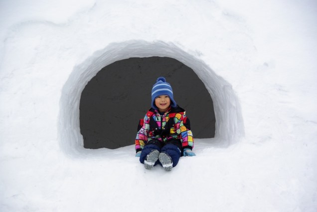 Criança brinca durante o festival Kamakura de Asahikawa, em Hokkaido, quando casinhas de neve são construídas para elas