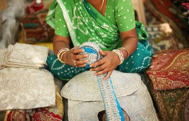 Mulher vende seda em mercado em Délhi, Índia