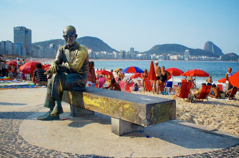A estátua de Carlos Drummond de Andrade é um disputado ponto para fotos na orla da <a href="https://viajeaqui.abril.com.br/estabelecimentos/br-rj-rio-de-janeiro-atracao-praia-de-copacabana" rel="praia de Copacabana" target="_blank">praia de Copacabana</a>