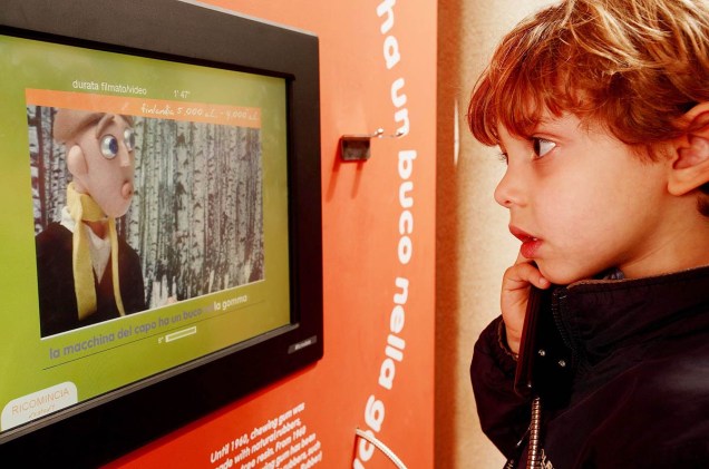 Criança interage com painel no museu