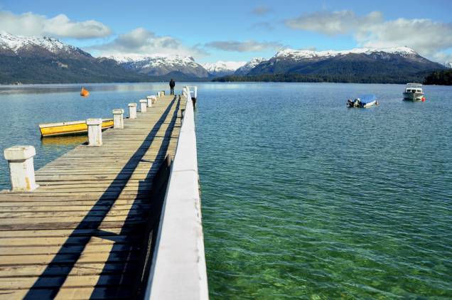 Píer corta a Baía Mansa, com lago e montanhas onipresentes Píer corta a Baía Mansa, com lago e montanhas onipresentes