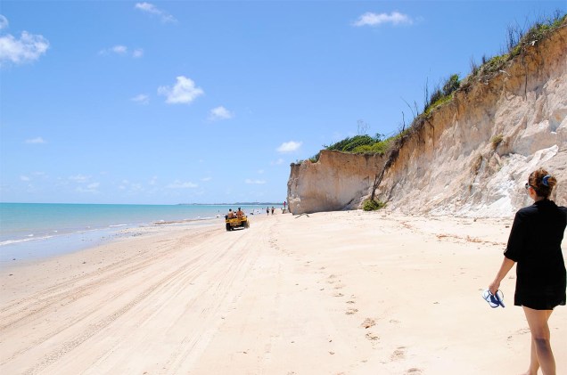 Turistas passeiam de bugue pela praia, de areia branquinha e mar azul-esverdeado