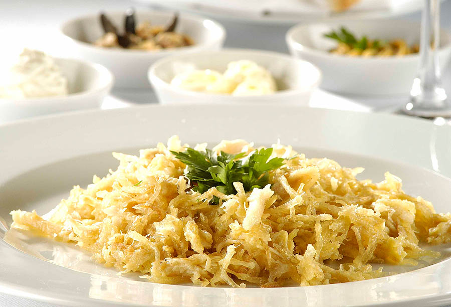 Um dos principais pratos da <strong>A Bela Sintra</strong>, em São Paulo, é o Bacalhau Dourado, em que o peixe vem desfiado e acompanhado de batata palha e ovos