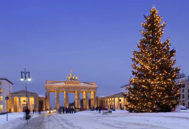 No fim do ano, o inverno chega à Berlim, junto com a neve; na foto, o Portão de Brandemburgo ao lado de uma árvore de Natal gigantesca