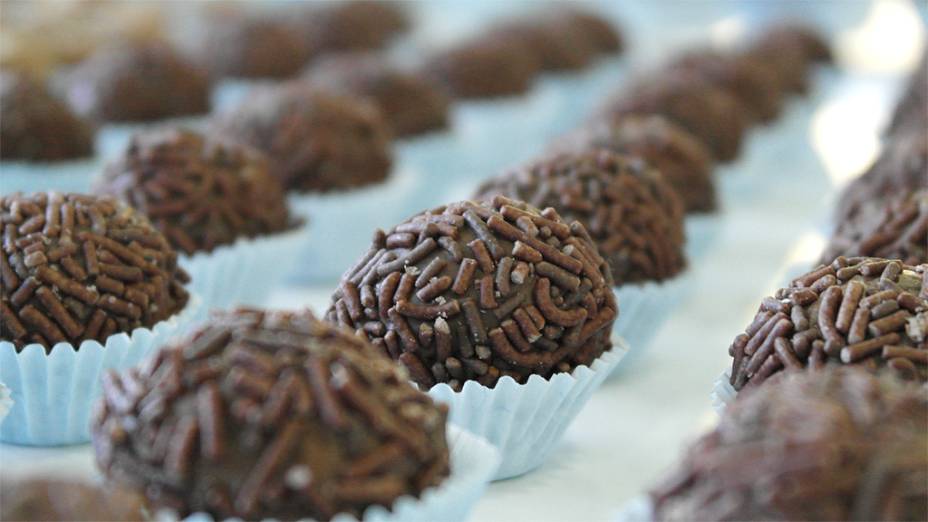 <strong>Brigadeiro</strong><br />  Alguns lugares do Brasil chamam o doce de negrinho, mas o nome brigadeiro vence de longe. As bolinhas de chocolate teriam sido feitas no <a href="https://viajeaqui.abril.com.br/cidades/br-rj-rio-de-janeiro" rel="Rio de Janeiro" target="_self">Rio de Janeiro</a>, para as festas que arrecadavam dinheiro para a candidatura do Brigadeiro Eduardo Gomes à presidência em 1946. Ele perdeu na urna para Eurico Gaspar Dutra, mas ganhou a doce homenagem – política também traz coisas boas!