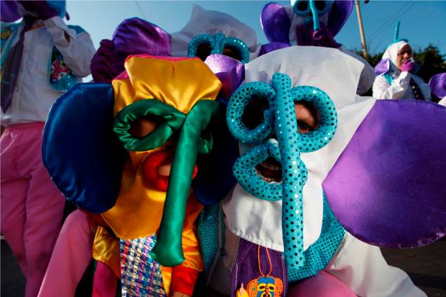 As máscaras coloridas, com longos narizes e grandes orelhas, são as marimondas, personagens típicos do Carnaval de Barranquilla, na Colômbia