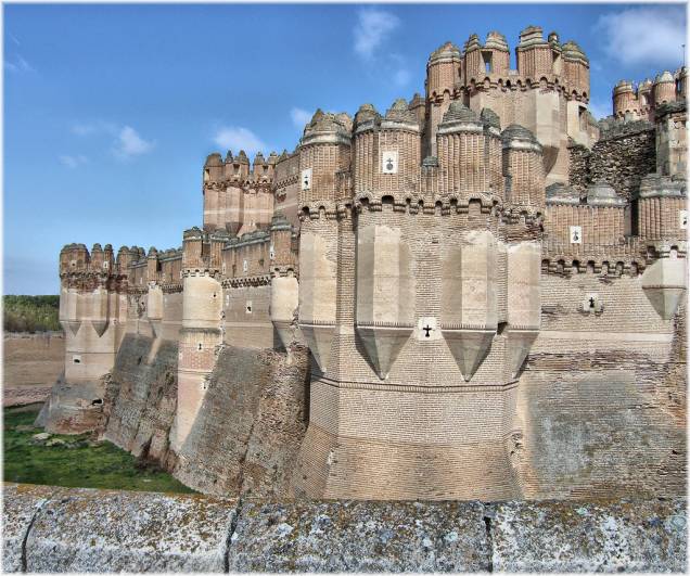 <strong>Castelo de Coca, <a href="http://viajeaqui.abril.com.br/paises/espanha" rel="Espanha" target="_blank">Espanha</a></strong>                        Há uma boa razão pela qual há duas regiões da <a href="http://viajeaqui.abril.com.br/paises/espanha">Espanha</a> que são conhecidas como Castela. Castilla-La Mancha e Castilla y León são salpicadas por dezenas de castelos medievais, simples ou imensos, testemunhas do longo e belicoso período que marcou a Reconquista. De lado a lado cristãos e mouros – e seus aliados, que poderiam ser tanto, vejam só, cristãos ou mouros – levantaram, conquistaram, sitiaram, ampliaram e reformaram fortificações. Boa parte destas magníficas construções são importantes atrações turísticas como o <a href="http://viajeaqui.abril.com.br/estabelecimentos/espanha-segovia-atracao-alcazar-de-segovia">Alcázar de Segóvia</a> e o Castillo de La Mota. O Castelo de Coca, próximo a <a href="http://viajeaqui.abril.com.br/cidades/espanha-segovia">Segóvia</a>, tem todos os elementos que o tornam perfeito em nossas imaginações infantis: torres, ameias, fosso e ponte