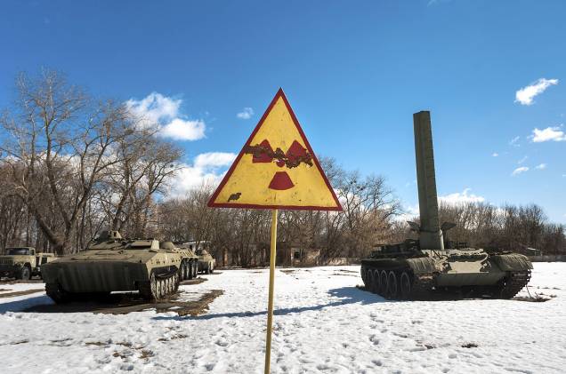 Tanques de guerra também jazem ao lado de placas com aviso de radiação, que estão por todos os lugares