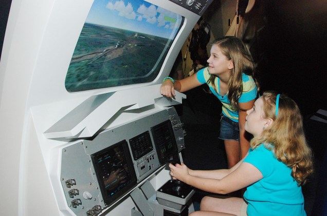 Crianças brincam em um simulador de pouso de ônibus espaciais no Space Shuttle Atlantis, uma das atrações do Kennedy Space Center, no Cabo Canaveral