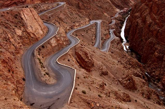 Taí um jeito acidentadíssimo de ir de um ponto a outro. A estrada das “mil kasbahs” (fortalezas antigas) sobe a Garganta Dades, um cânion de cinema na cordilheira Atlas, no Marrocos. É um estonteante zigue-zague ribanceira acima. As curvas, radicais, vão cortando um ambiente desértico, daqueles de levantar poeira. E o caminho vai passando por aldeias dos povos berberes e bosques de palmeiras. Lindo, diferentão. E, é, meio perigoso. Taí um jeito acidentadíssimo de ir de um ponto a outro. A estrada das “mil kasbahs” (fortalezas antigas) sobe a Garganta Dades, um cânion de cinema na cordilheira Atlas, no Marrocos. É um estonteante zigue-zague ribanceira acima. As curvas, radicais, vão cortando um ambiente desértico, daqueles de levantar poeira. E o caminho vai passando por aldeias dos povos berberes e bosques de palmeiras. Lindo, diferentão. E, é, meio perigoso.
