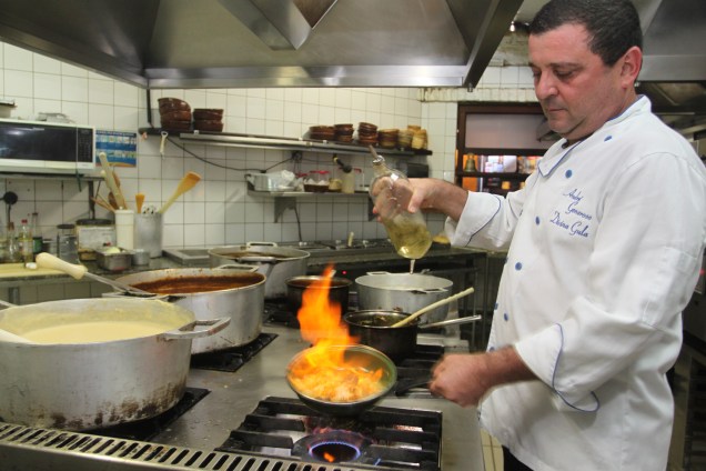 O chef André Generoso flamba o peixe grelhado com uvas e legumes O chef André Generoso flamba o peixe grelhado com uvas e legumes