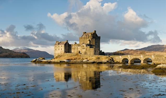 <strong>Eilean Donan, <a href="http://viajeaqui.abril.com.br/paises/escocia" rel="Escócia" target="_blank">Escócia</a></strong>                            O protótipo do castelo mal-assombrado escocês, <a href="http://viajeaqui.abril.com.br/estabelecimentos/reino-unido-highlands-atracao-eilean-donan-castle">Eilean Donan</a> possui não só uma localização cênica, em uma ilhota no Loch Duich, mas também uma arquitetura com todos os elementos dramáticos básicos. A pequena edificação já foi utilizada em dezenas de filmes e comerciais, como a fita de ação <em>Highlander</em> (1986)