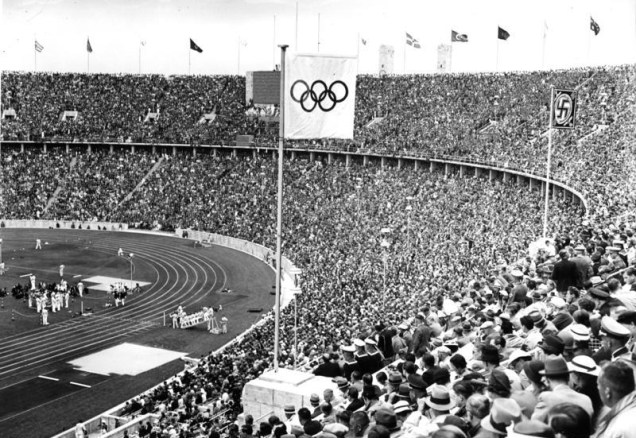 <strong>10. <a href="https://viajeaqui.abril.com.br/cidades/alemanha-berlim" target="_blank" rel="noopener">Berlim</a>, <a href="https://viajeaqui.abril.com.br/paises/alemanha" target="_blank" rel="noopener">Alemanha</a>, 1936</strong> O famoso revezamento da tocha olímpica começou nas Olimpíadas de 1936, com o fogo eterno sendo transportado de <a href="https://viajeaqui.abril.com.br/cidades/grecia-atenas" target="_blank" rel="noopener">Atenas</a>, na <a href="https://viajeaqui.abril.com.br/paises/grecia" target="_blank" rel="noopener">Grécia</a>, até o Estádio Olímpico de Berlim (foto). Os jogos foram marcados pela propaganda nazista, que se alastrava por toda a Alemanha na época.