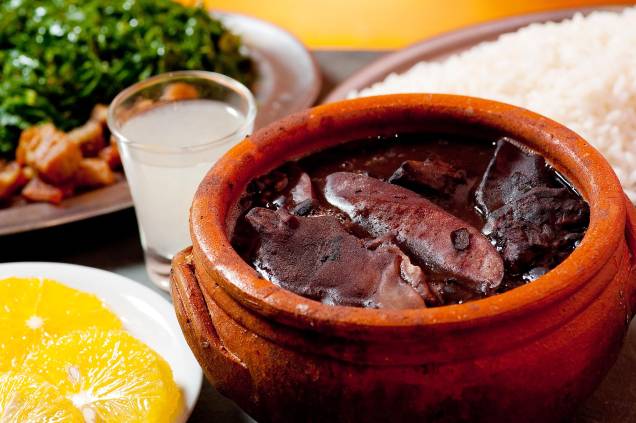 <strong>Feijoada</strong> Presente em cardápios de todo o país e famosa até no exterior, ela faz jus ao título de prato nacional. Embora existam muitas versões da receita, prevalece a servida na cidade do <a href="https://viajeaqui.abril.com.br/cidades/br-rj-rio-de-janeiro" target="_blank" rel="noopener">Rio de Janeiro</a>, onde surgiu o primeiro registro do termo "feijoada". Na panela, acrescido de carne-seca, paio, linguiça, lombo, costela, pé, orelha e rabo de porco, o feijão-preto rende um saboroso e consistente caldo, servido com arroz, laranja, torresmo e couve (em diversos lugares, também com linguiça frita e banana à milanesa). Antes de ir para o fogão, as carnes precisam ser dessalgadas, processo que deve começar pelo menos um dia antes do cozimento. <strong>Quem prepara:</strong> <a href="https://www.academiadacachaca.com.br/" target="_blank" rel="noopener">Academia da Cachaça</a>, <a href="https://www.facebook.com/aconchego.carioca/" target="_blank" rel="noopener">Aconchego Carioca</a>, <a href="https://www.facebook.com/BardoDavidOficial/" target="_blank" rel="noopener">Bar do David</a>, <a href="https://bardomineiro.net/" target="_blank" rel="noopener">Bar do Mineiro</a>, no <a href="https://viajeaqui.abril.com.br/cidades/br-rj-rio-de-janeiro" target="_blank" rel="noopener">Rio de Janeiro (RJ)</a> <strong>Feijoada</strong> Presente em cardápios de todo o país e famosa até no exterior, ela faz jus ao título de prato nacional. Embora existam muitas versões da receita, prevalece a servida na cidade do <a href="https://viajeaqui.abril.com.br/cidades/br-rj-rio-de-janeiro" target="_blank" rel="noopener">Rio de Janeiro</a>, onde surgiu o primeiro registro do termo "feijoada". Na panela, acrescido de carne-seca, paio, linguiça, lombo, costela, pé, orelha e rabo de porco, o feijão-preto rende um saboroso e consistente caldo, servido com arroz, laranja, torresmo e couve (em diversos lugares, também com linguiça frita e banana à milanesa). Antes de ir para o fogão, as carnes precisam ser dessalgadas, processo que deve começar pelo menos um dia antes do cozimento. <strong>Quem prepara:</strong> <a href="https://www.academiadacachaca.com.br/" target="_blank" rel="noopener">Academia da Cachaça</a>, <a href="https://www.facebook.com/aconchego.carioca/" target="_blank" rel="noopener">Aconchego Carioca</a>, <a href="https://www.facebook.com/BardoDavidOficial/" target="_blank" rel="noopener">Bar do David</a>, <a href="https://bardomineiro.net/" target="_blank" rel="noopener">Bar do Mineiro</a>, no <a href="https://viajeaqui.abril.com.br/cidades/br-rj-rio-de-janeiro" target="_blank" rel="noopener">Rio de Janeiro (RJ)</a>