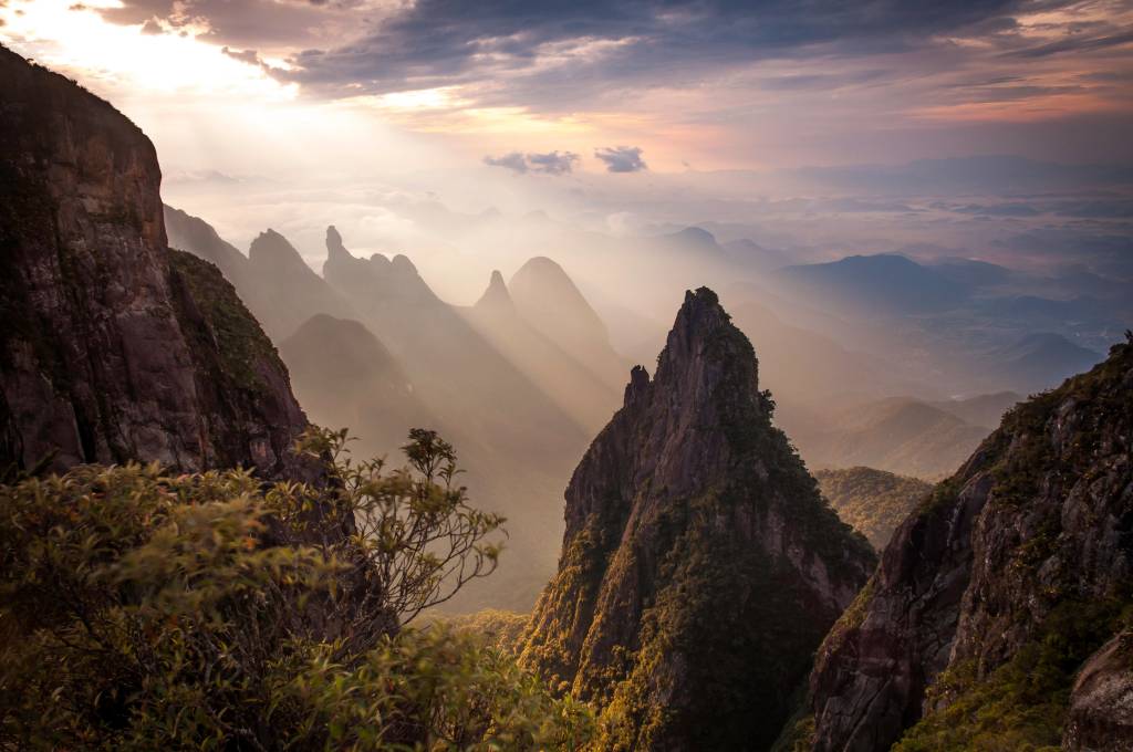 Formações rochosas e o pico Dedo de Deus ao fundo, no Parque Nacional da Serra dos Órgãos, Estado do Rio de Janeiro, Brasil