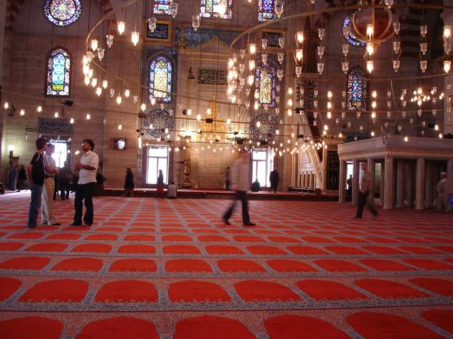 <strong>Sala de Orações</strong>Parte fundamental na composição arquitetônica das mesquitas, a sala de orações não dispõe de cadeiras, como as igrejas cristãs, sendo muitas vezes acompanhadas por tapetes. A parede <em>qibla </em>- sempre orientada para Meca, o <em>mihrab </em>(nicho que indica a direção das orações) e o <em>minbar</em> (púlpito com degraus, à direita do <em>mihrab</em>) são elementos importantes que se encontram dentro de salas de orações, como esta, na mesquita de Solimão, em <a href="http://viajeaqui.abril.com.br/cidades/turquia-istambul" rel="Istambul " target="_blank">Istambul </a>