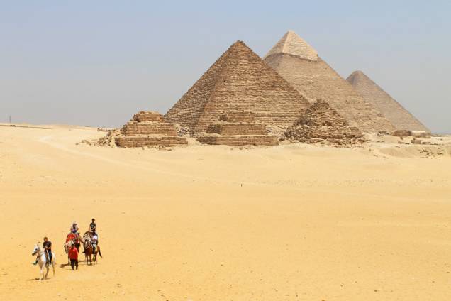Turistas visitam as Pirâmides de Gizé, nas proximidades do Cairo, no Egito; para chegar ali, você pode pegar um trem e descer na estação de Giza - a caminhada até o sítio arqueológico é longa, mas é uma boa maneira de visitar o local com independência