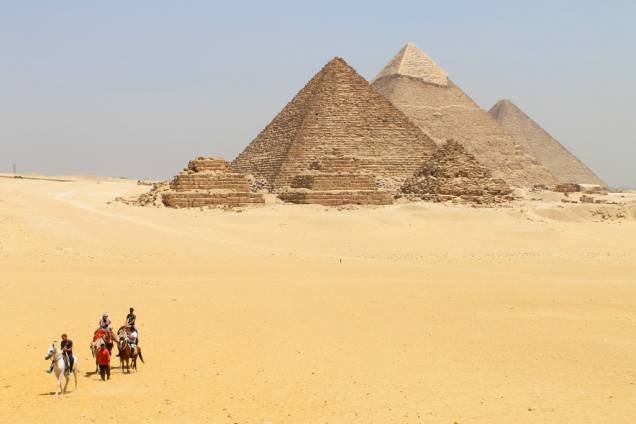 Turistas visitam as Pirâmides de Gizé, nas proximidades do Cairo, no Egito; para chegar ali, você pode pegar um trem e descer na estação de Giza - a caminhada até o sítio arqueológico é longa, mas é uma boa maneira de visitar o local com independência Turistas visitam as Pirâmides de Gizé, nas proximidades do Cairo, no Egito; para chegar ali, você pode pegar um trem e descer na estação de Giza - a caminhada até o sítio arqueológico é longa, mas é uma boa maneira de visitar o local com independência